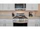 Close up of stainless steel stove and microwave in modern, white kitchen at 5317 Coral Reef Way, Bradenton, FL 34211