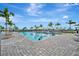 A large, rectangular pool surrounded by palm trees, lounge chairs, and well-maintained pavers under a bright blue sky at 5317 Coral Reef Way, Bradenton, FL 34211