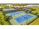 Aerial view of well-maintained tennis courts with lush landscaping and nearby pond views within a vibrant community at 5317 Coral Reef Way, Bradenton, FL 34211