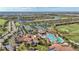 Aerial view featuring golf course, tennis courts, clubhouse, and resort-style community pool at 5517 Palmer Cir # 203, Bradenton, FL 34211
