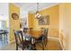 Warm dining area with a wooden table, artwork, and modern lighting fixtures at 5517 Palmer Cir # 203, Bradenton, FL 34211