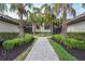 Inviting exterior entryway with lush landscaping, stone walkway, and stately palm trees at 5517 Palmer Cir # 203, Bradenton, FL 34211