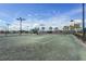 Outdoor tennis court with manicured landscaping and lighting for evening play and lush palm tree views at 5517 Palmer Cir # 203, Bradenton, FL 34211