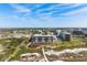 Expansive aerial view of the condominium complex near pristine beach, with beautiful landscaping and blue skies at 5740 Midnight Pass Rd # 402, Sarasota, FL 34242