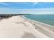 Long stretch of beach with people enjoying clear water, and city views at 5740 Midnight Pass Rd # 402, Sarasota, FL 34242