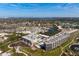 Aerial view of a condo complex with lake views, meticulously landscaped grounds, and ample parking at 5740 Midnight Pass Rd # 402, Sarasota, FL 34242