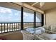 Outdoor ocean view balcony furnished with a glass table and floral print chairs to enjoy the beach view at 5740 Midnight Pass Rd # 402, Sarasota, FL 34242