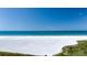 Picturesque beach scene with clear blue water and parasailers in the distance at 5740 Midnight Pass Rd # 402, Sarasota, FL 34242