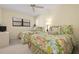 Cozy bedroom featuring two beds with floral bedding, a ceiling fan, and a bright window at 5740 Midnight Pass Rd # 402, Sarasota, FL 34242