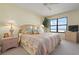 Relaxing bedroom featuring a large window with ocean views, a ceiling fan, and neutral decor at 5740 Midnight Pass Rd # 402, Sarasota, FL 34242