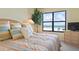 Comfortable bedroom has a beautiful view of the ocean, large window, and calming decor at 5740 Midnight Pass Rd # 402, Sarasota, FL 34242