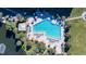 Aerial view of a large community pool with lounge chairs and umbrellas, perfect for relaxation and recreation at 5740 Midnight Pass Rd # 402, Sarasota, FL 34242