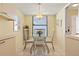 Bright dining area features a glass-top table, seating for four, and a view through the window at 5740 Midnight Pass Rd # 402, Sarasota, FL 34242