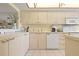 White kitchen features bright white cabinets, and stainless steel appliances at 5740 Midnight Pass Rd # 402, Sarasota, FL 34242