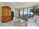 Bright living room features a ceiling fan, ocean view balcony access, and comfortable seating at 5740 Midnight Pass Rd # 402, Sarasota, FL 34242