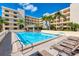 Resort-style pool area with lounge chairs and lush landscaping near the building at 5740 Midnight Pass Rd # 402, Sarasota, FL 34242
