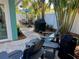 Inviting backyard patio with outdoor dining set, grill, and comfortable seating area amidst lush tropical landscaping at 5802 De Palmas Ave, Holmes Beach, FL 34217