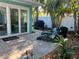Charming outdoor space with comfortable seating, a grill, lush greenery, and seamless access through sliding glass doors at 5802 De Palmas Ave, Holmes Beach, FL 34217