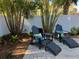 Private backyard featuring Adirondack chairs with footrests, creating a perfect spot to unwind in a tropical setting at 5802 De Palmas Ave, Holmes Beach, FL 34217