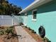 Turquoise exterior with white fence, brick paver walkway and lush, mature landscaping at 5802 De Palmas Ave, Holmes Beach, FL 34217