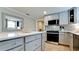 Well-appointed kitchen with gray cabinets, stainless steel appliances, and ample counter space at 5802 De Palmas Ave, Holmes Beach, FL 34217