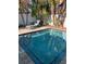 Sparkling pool with pristine blue water and elegant tile trim, surrounded by tropical foliage and a cozy lounge chair at 5802 De Palmas Ave, Holmes Beach, FL 34217