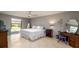 Relaxing bedroom with tile flooring, neutral walls, ceiling fan, and ample sunlight at 5859 Lincoln Rd, Venice, FL 34293