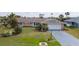 Charming single-story home featuring a well-manicured lawn, stone accents, and an attached two-car garage at 5859 Lincoln Rd, Venice, FL 34293