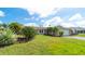 Well-maintained front yard with lush green grass and mature tropical landscaping, providing great curb appeal at 5859 Lincoln Rd, Venice, FL 34293