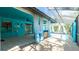 Inviting outdoor patio with bar seating, ceiling fan, and a seamless transition to the screened pool area at 5859 Lincoln Rd, Venice, FL 34293