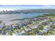 An aerial view features a waterfront community with lush landscapes and distant city views at 5869 Tidewood Ave # 7, Sarasota, FL 34231