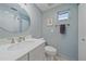 This bathroom offers a decorative mirror, a granite countertop, and a white color palette at 5869 Tidewood Ave # 7, Sarasota, FL 34231