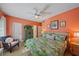 Cozy bedroom featuring bright orange walls, wood-look floors, and a view into an en suite bathroom at 5869 Tidewood Ave # 7, Sarasota, FL 34231