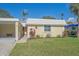 Quaint home featuring a bright yellow facade, a well-manicured lawn, and verdant landscaping at 5869 Tidewood Ave # 7, Sarasota, FL 34231