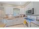 Bright kitchen featuring white cabinetry, modern appliances, and a window with a view at 5869 Tidewood Ave # 7, Sarasota, FL 34231