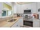 Bright kitchen featuring stainless appliances, granite countertops, and a stylish faucet, ideal for cooking enthusiasts at 5869 Tidewood Ave # 7, Sarasota, FL 34231
