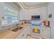 Well-lit kitchen featuring white cabinetry, functional appliances, and ample counter space at 5869 Tidewood Ave # 7, Sarasota, FL 34231