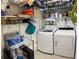 Organized laundry room features washer, dryer and shelving for ample storage space at 5869 Tidewood Ave # 7, Sarasota, FL 34231