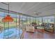 Comfortable sunroom filled with natural light, featuring wicker furniture and views of the landscaped backyard at 5869 Tidewood Ave # 7, Sarasota, FL 34231