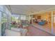 Bright sunroom leading to a living room with a large sliding glass door and comfortable wicker furniture at 5869 Tidewood Ave # 7, Sarasota, FL 34231