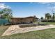 Back exterior view with a pool, covered patio, and lawn at 605 15Th Avenue E Dr, Palmetto, FL 34221