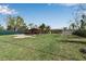 Large grassy backyard with a covered patio, in-ground pool, and mature landscaping at 605 15Th Avenue E Dr, Palmetto, FL 34221