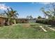 Grassy backyard featuring a white fence, mature trees, and a building at 605 15Th Avenue E Dr, Palmetto, FL 34221