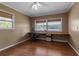 Neutral room with hardwood floors, windows, a built-in desk, chair and a ceiling fan with light at 605 15Th Avenue E Dr, Palmetto, FL 34221