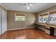 Neutral room with hardwood floors, windows, a built-in desk, chair and a ceiling fan with light at 605 15Th Avenue E Dr, Palmetto, FL 34221