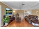 Open-concept living room features hardwood floors, a comfortable couch, and a large-screen television at 605 15Th Avenue E Dr, Palmetto, FL 34221