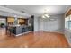 Open-concept living room with hardwood floors and a view into the kitchen with a breakfast bar at 605 15Th Avenue E Dr, Palmetto, FL 34221