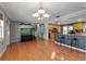 Open-concept living room with hardwood floors and a view into the kitchen with a breakfast bar at 605 15Th Avenue E Dr, Palmetto, FL 34221