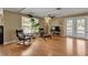 Open living room featuring hardwood floors, ceiling fan, and double doors to the outdoor living space at 605 15Th Avenue E Dr, Palmetto, FL 34221