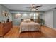 Spacious main bedroom featuring hardwood floors, ample lighting, soft colors, and ceiling fan at 605 15Th Avenue E Dr, Palmetto, FL 34221